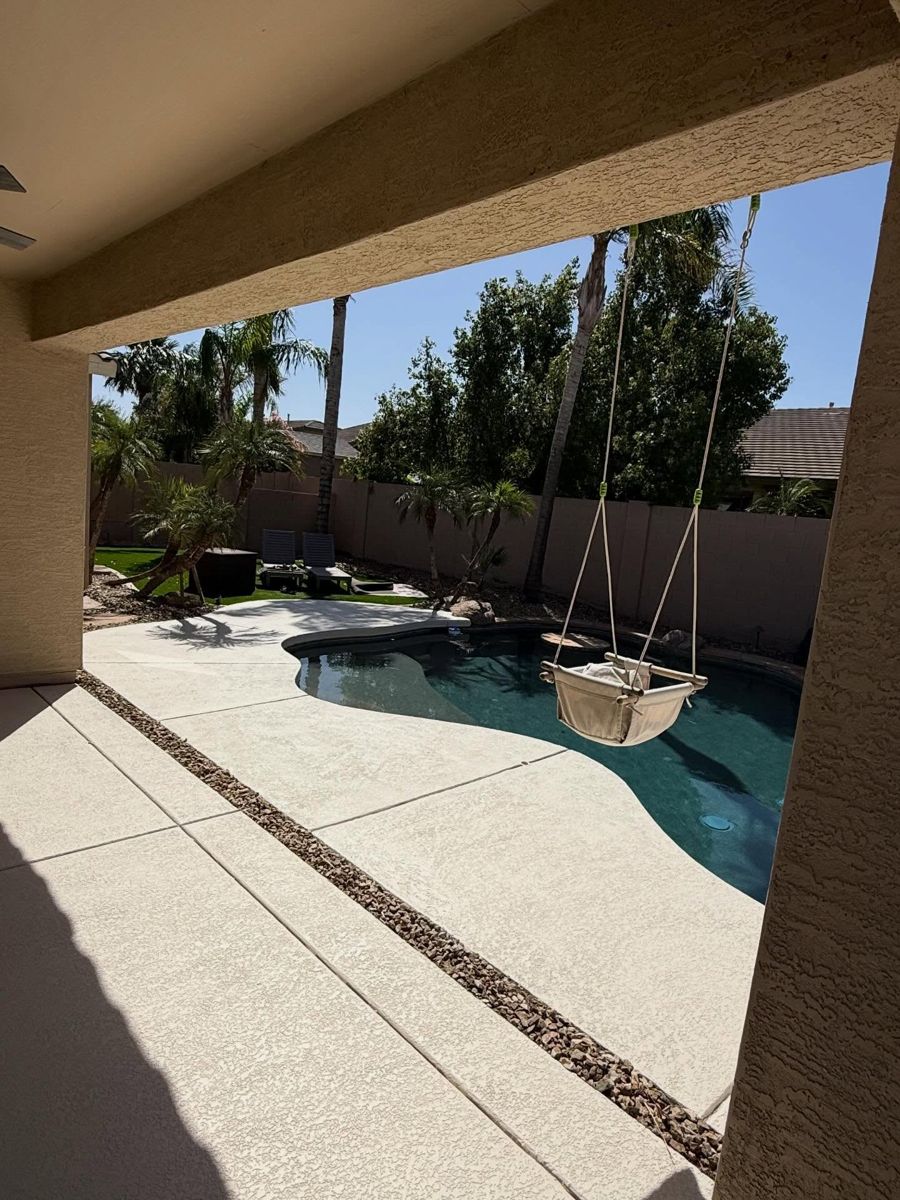 Cream textured deck under a covered patio with a hanging swing